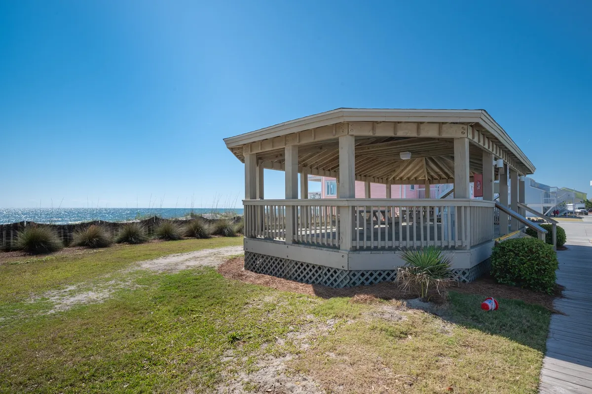 This image showcases a pavilion structure with an unobstructed ocean view, surrounded by greenery. The space is ideal for gatherings, picnics, or simply soaking up the coastal atmosphere, embodying the allure of the beachside environment.